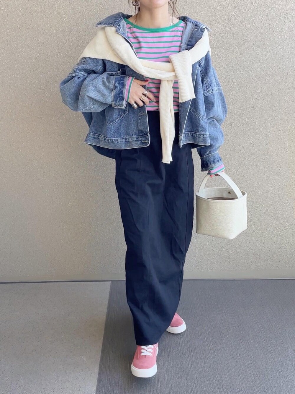 ピンク系のTシャツ/カットソー、ブラック系のスカート、ブルー系のデニムジャケットを着用したレディースの春コーディネートの5枚目の写真