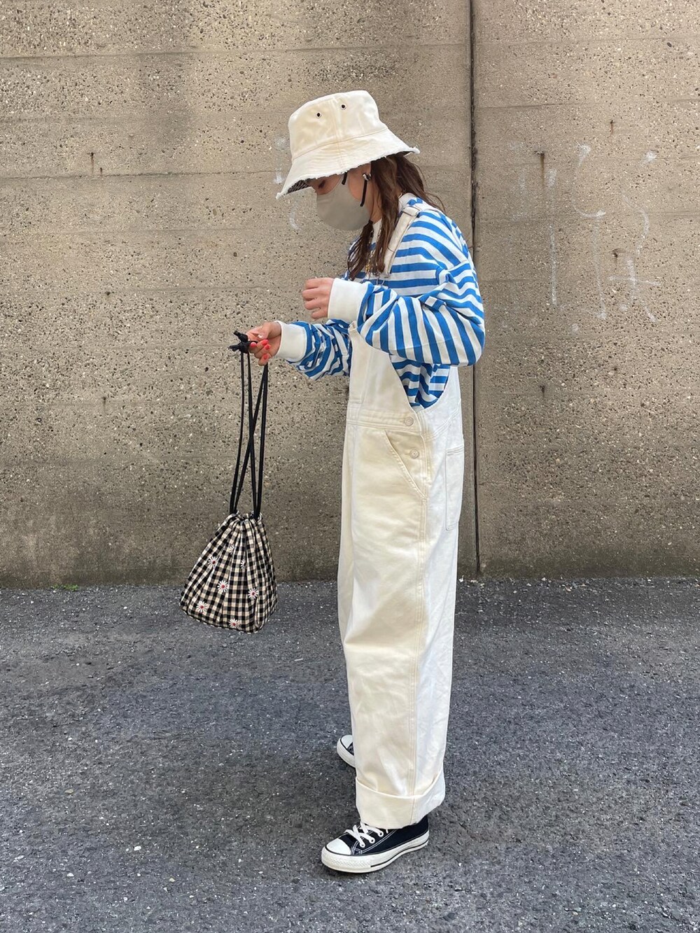 ブルー系のTシャツ/カットソー、ホワイト系のサロペット/オーバーオール、ベージュ系のミリタリージャケットを着用したレディースの春コーディネートの2枚目の写真