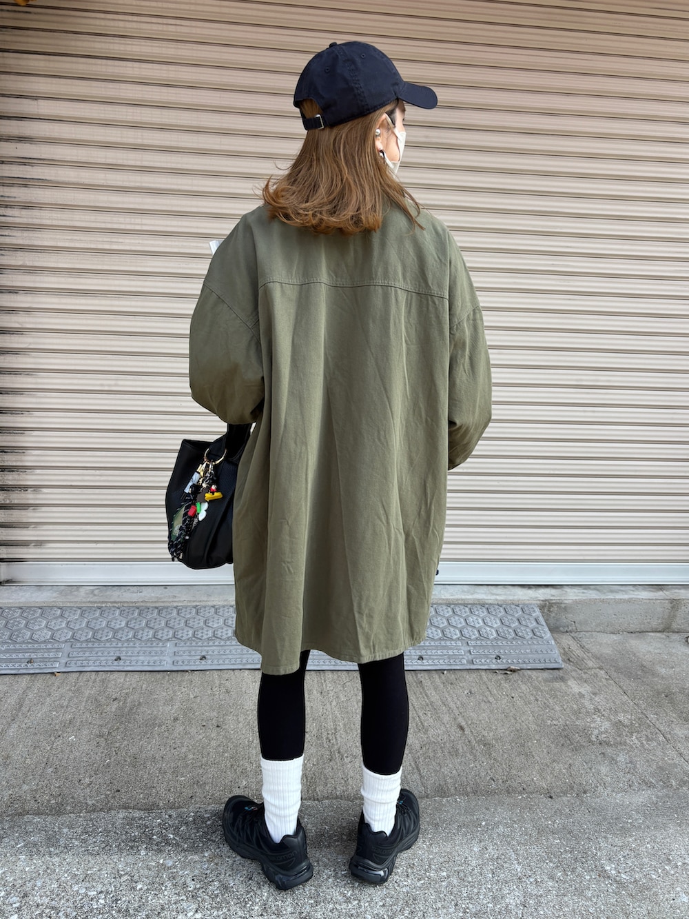 グリーン系のミリタリージャケット、ブルー系のデニムスカート、グレー系のスウェットを着用したレディースの冬コーディネートの2枚目の写真