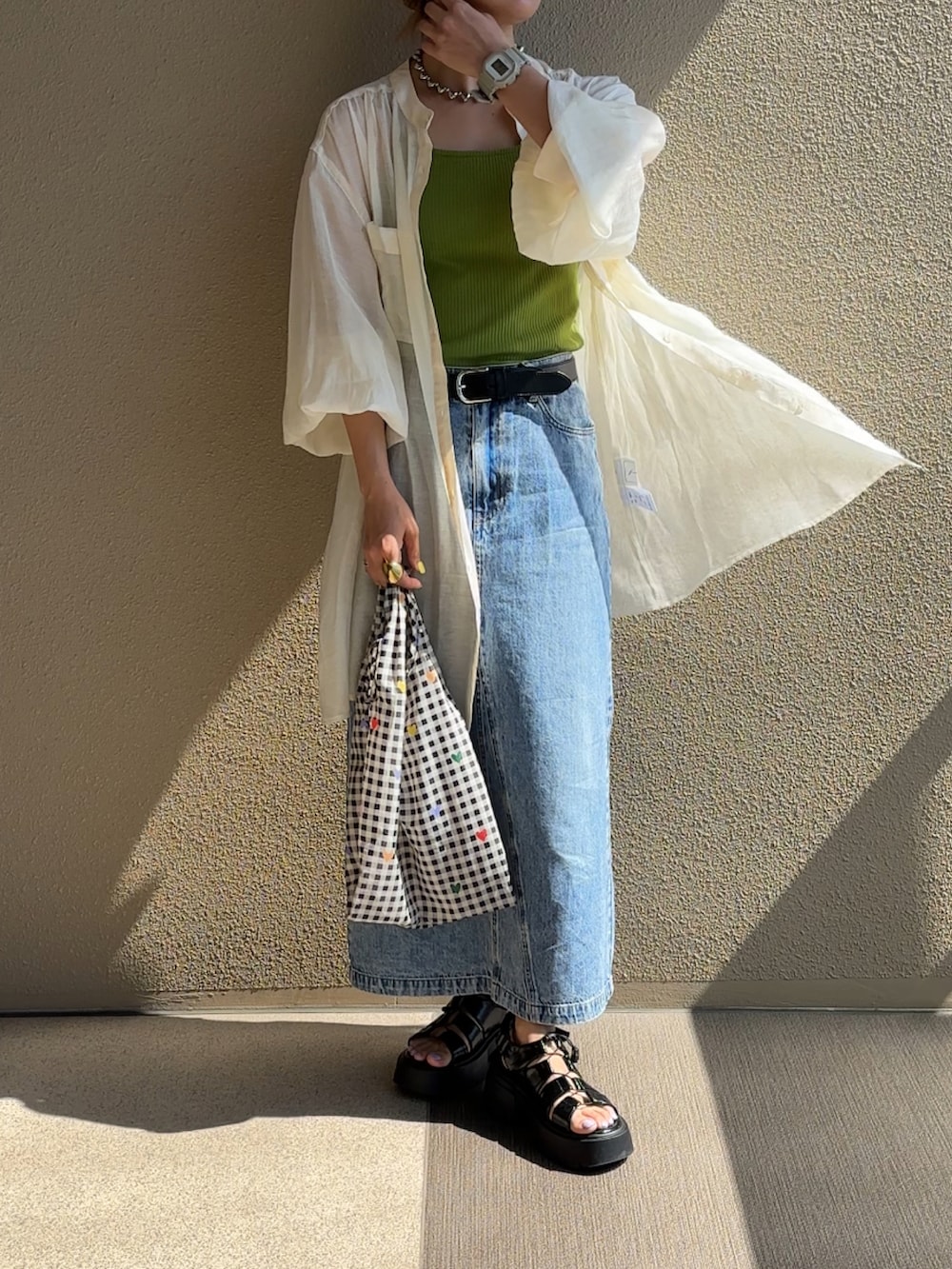 ホワイト系のシャツ/ブラウス、ブルー系のデニムスカート、ブラック系のサンダルを着用したレディースの春コーディネートの4枚目の写真