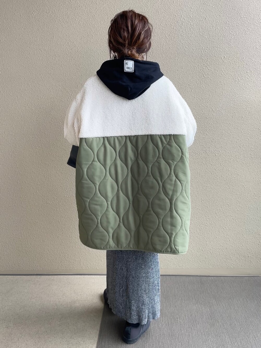 ホワイト系のノーカラージャケット、グリーン系のノーカラージャケット、ブラック系のスカートを着用したレディースの冬コーディネートの4枚目の写真