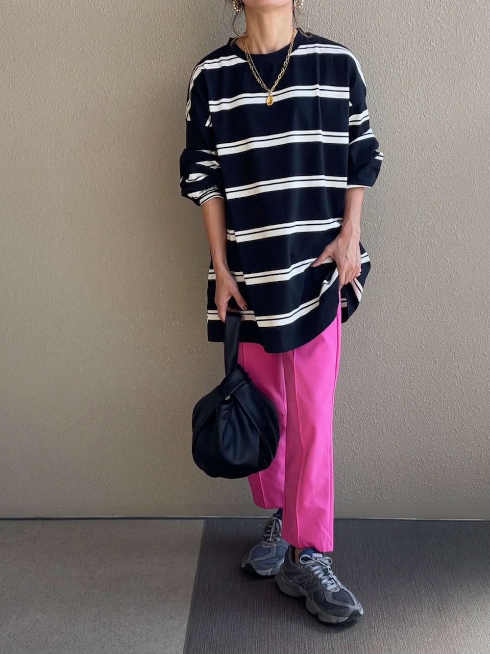 ブルー系のデニムパンツ、グリーン系のベスト、ブラック系のハンドバッグを着用したレディースの秋コーディネートの3枚目の写真