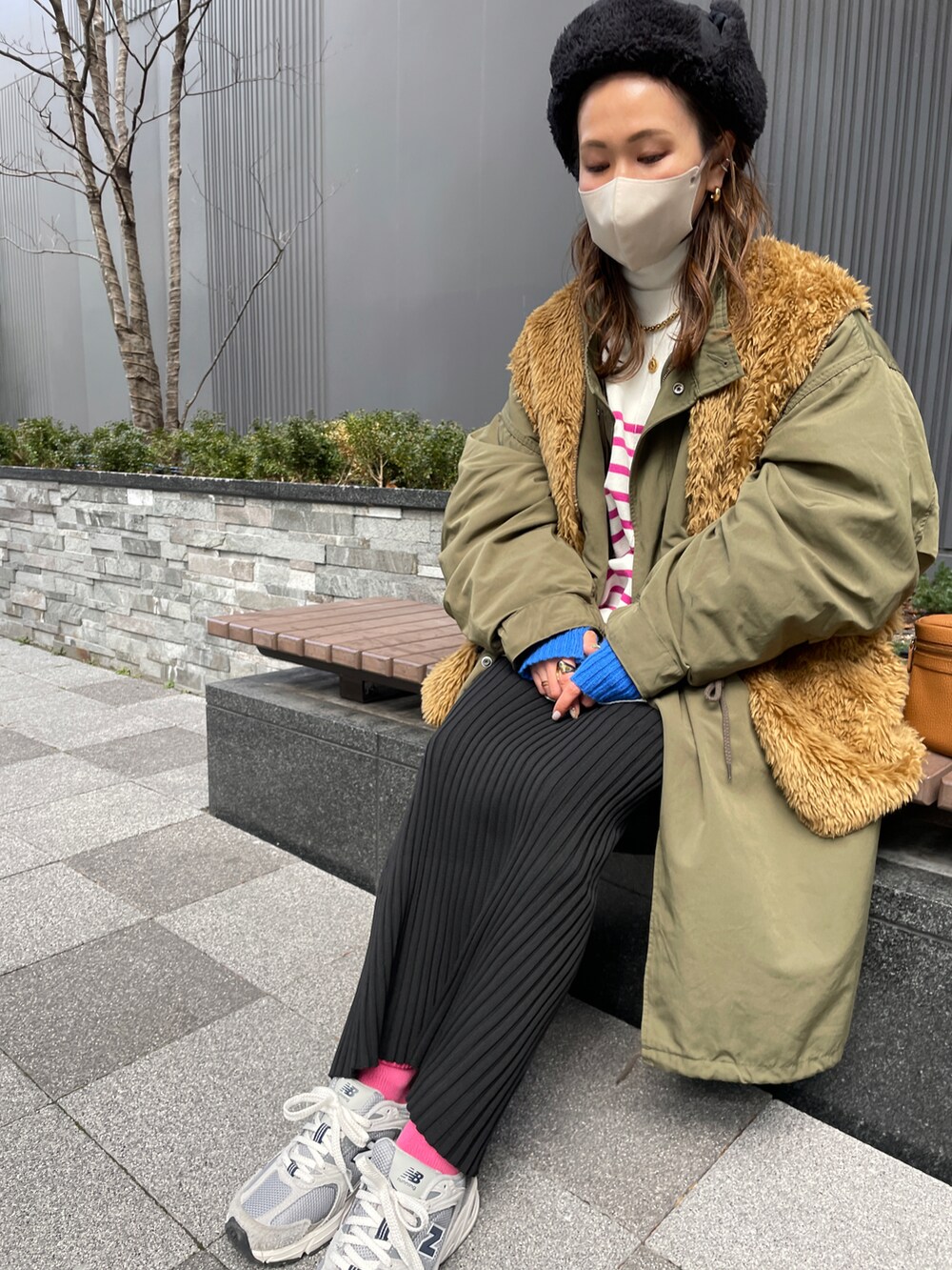 ピンク系のカーディガン/ボレロ、ブラック系のスカート、グリーン系のモッズコートを着用したレディースの冬コーディネートの4枚目の写真