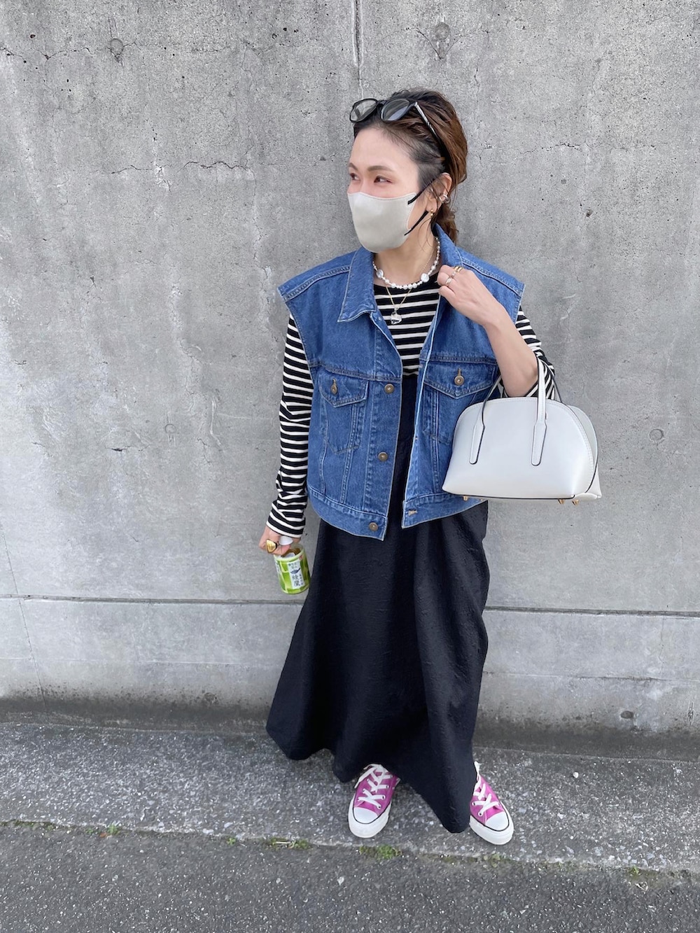 ブルー系のベスト、ブラック系のワンピース、ピンク系のスニーカーを着用したレディースの春コーディネートの2枚目の写真
