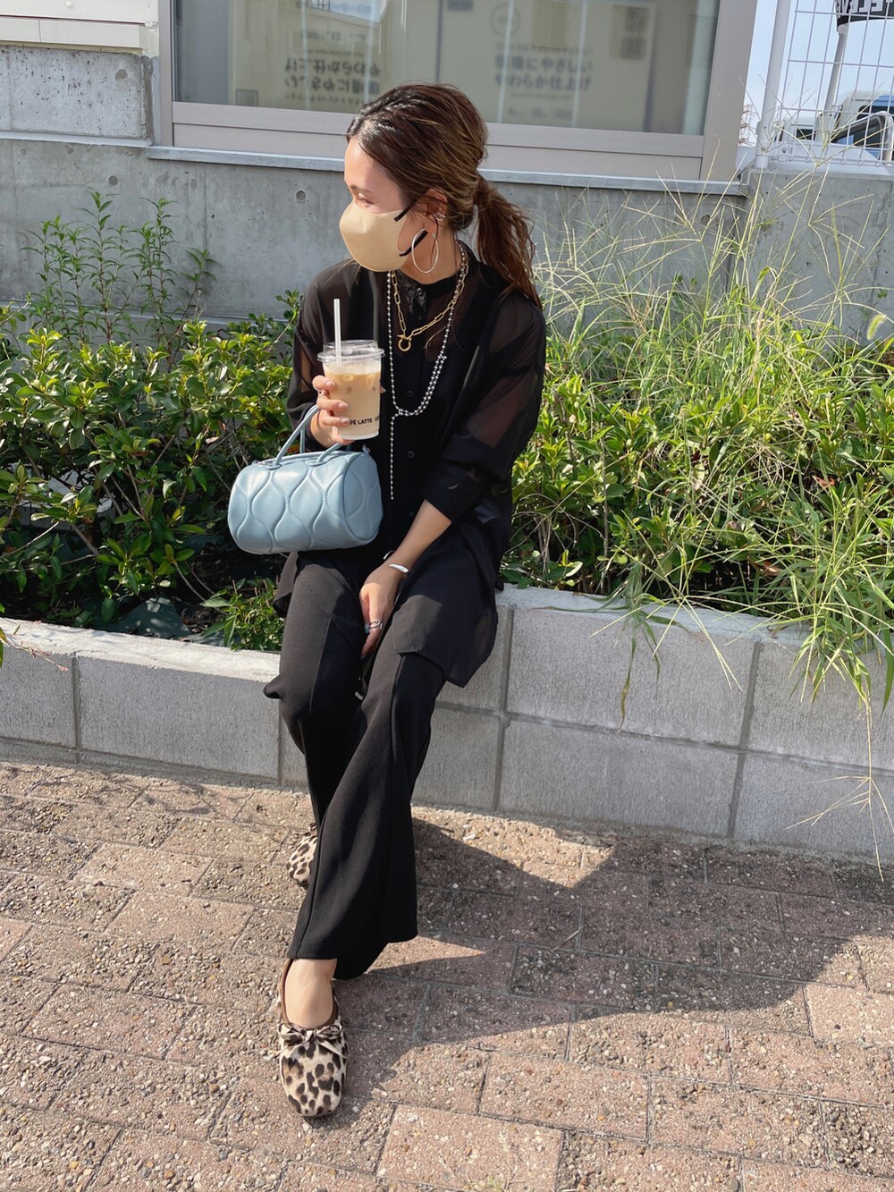 ブラック系のスラックス、ブラック系のTシャツ/カットソー、ブルー系のショルダーバッグを着用したレディースの秋コーディネートの4枚目の写真