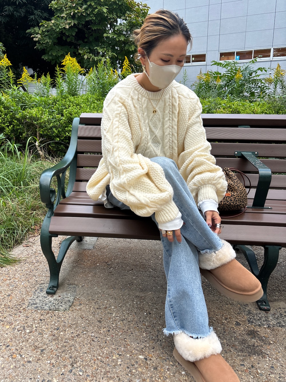 ホワイト系のニット/セーター、ブルー系のデニムパンツ、ブラウン系のブーツを着用したレディースの秋コーディネートの2枚目の写真