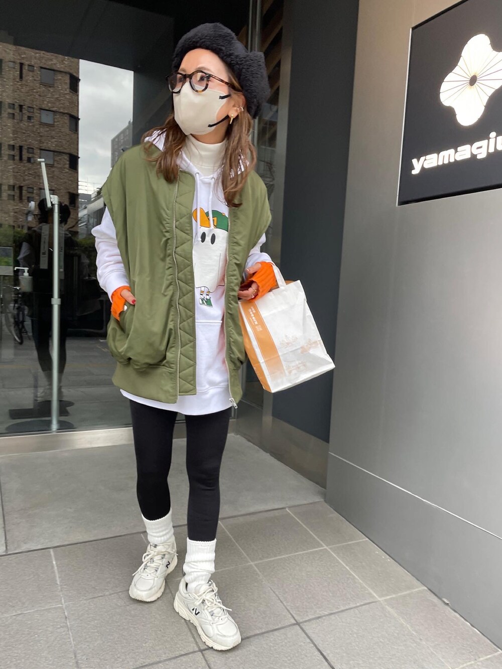 グリーン系のMA-1、ホワイト系のスニーカー、ブラック系のハットを着用したレディースの冬コーディネートの4枚目の写真