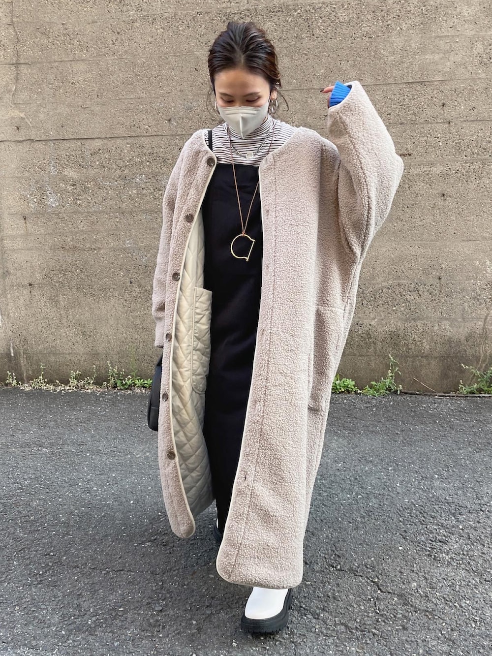 ホワイト系のその他アウター、ブラック系のワンピース、ブラック系のハンドバッグを着用したレディースの秋コーディネートの2枚目の写真