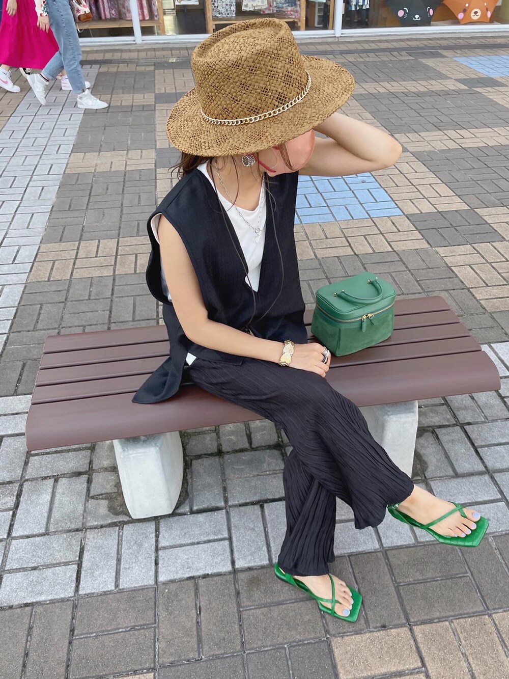 ブラック系のベスト、ブラック系のその他パンツ、グリーン系のサンダルを着用したレディースの夏コーディネートの4枚目の写真