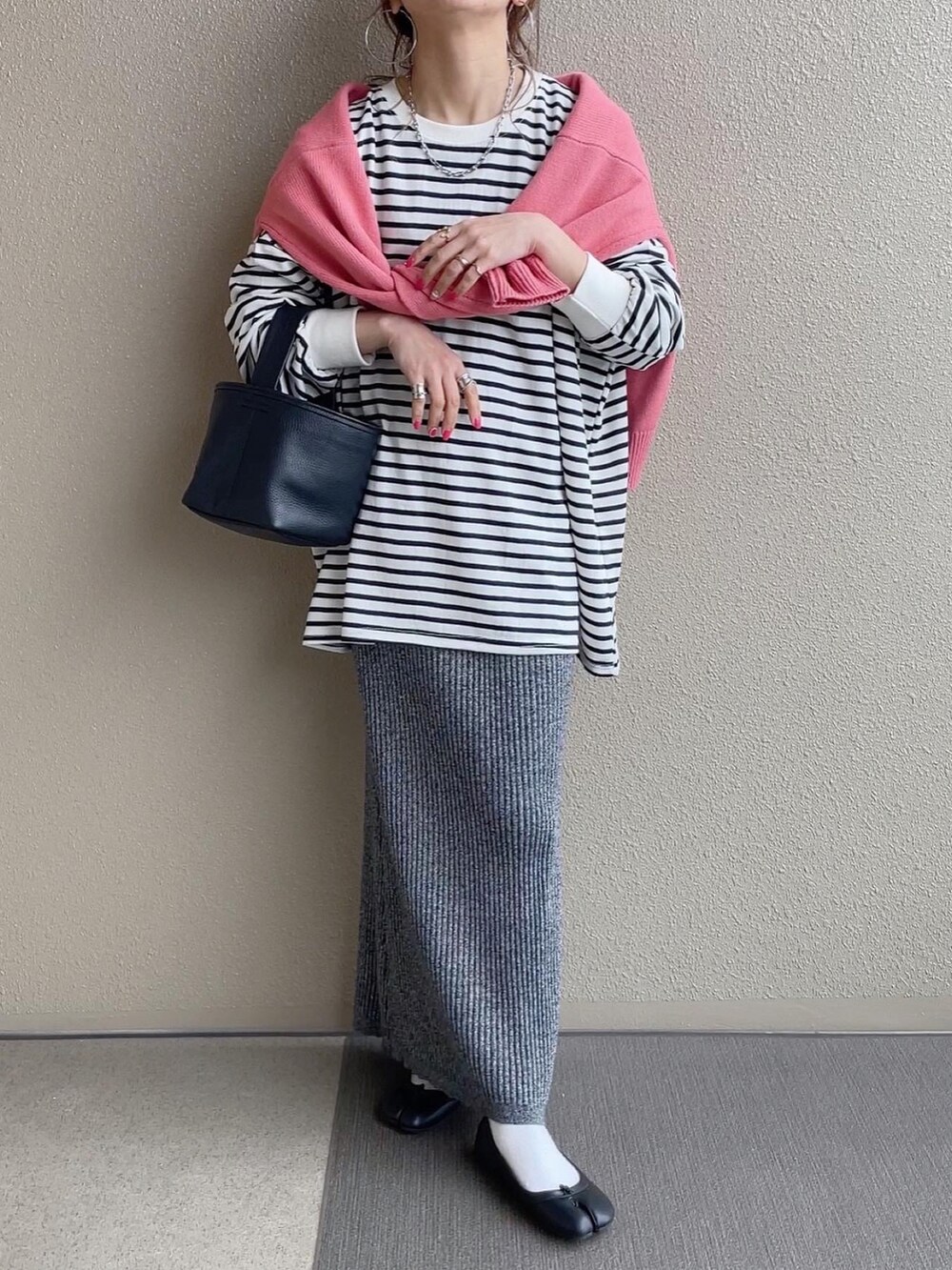 ブラック系のTシャツ/カットソー、ブラック系のスカート、オレンジ系のその他パンツを着用したレディースの春コーディネートの3枚目の写真