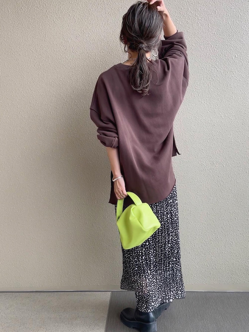 ピンク系のスウェット、ホワイト系のベスト、ブルー系のショルダーバッグを着用したレディースの秋コーディネートの5枚目の写真