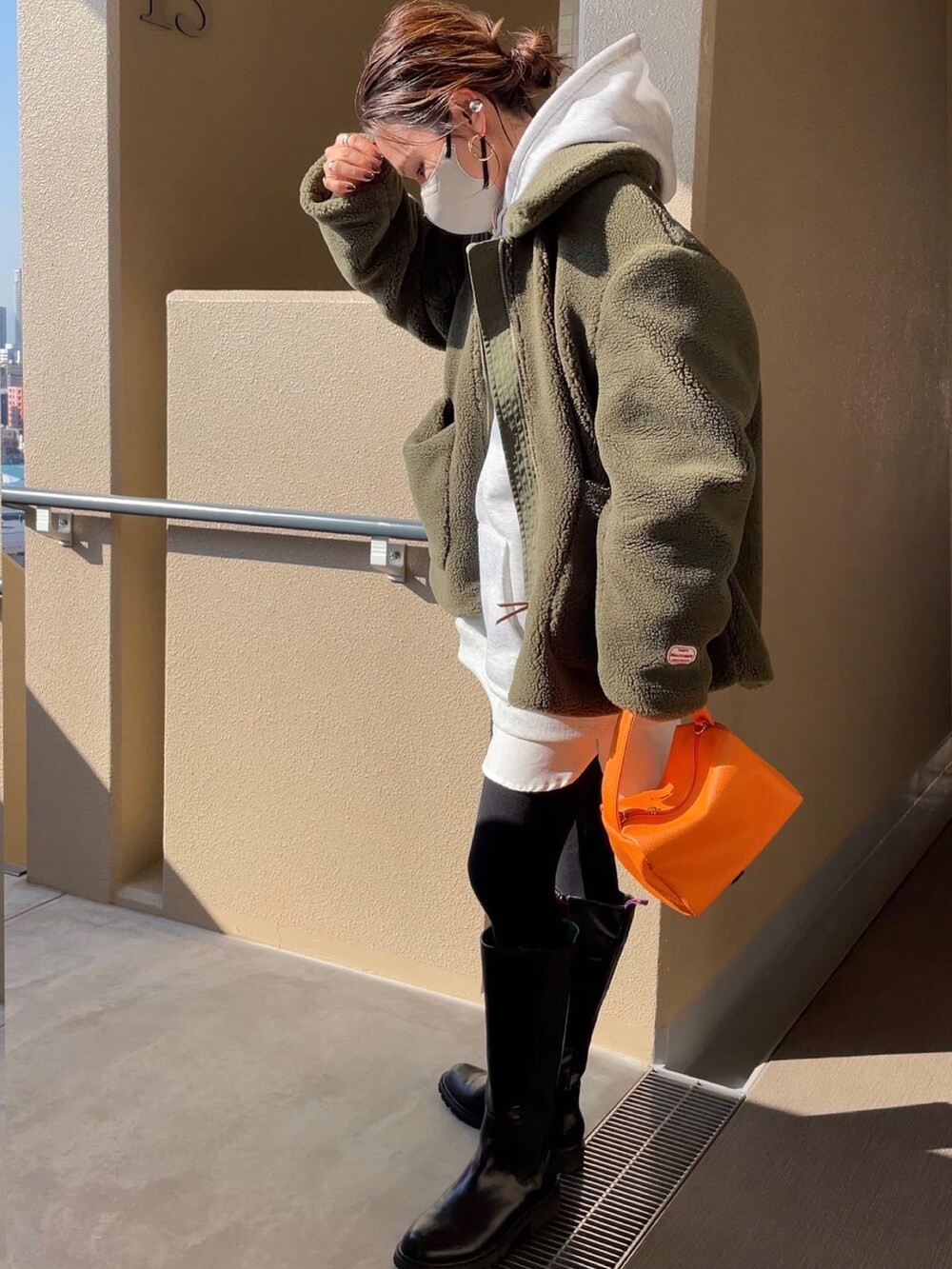 グリーン系のその他アウター、ブラック系のブーツを着用したレディースの秋コーディネートの2枚目の写真