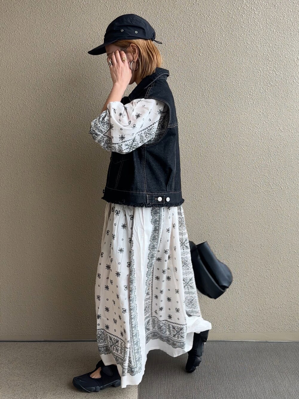 ブラック系のベストを着用したレディースの春コーディネートの3枚目の写真