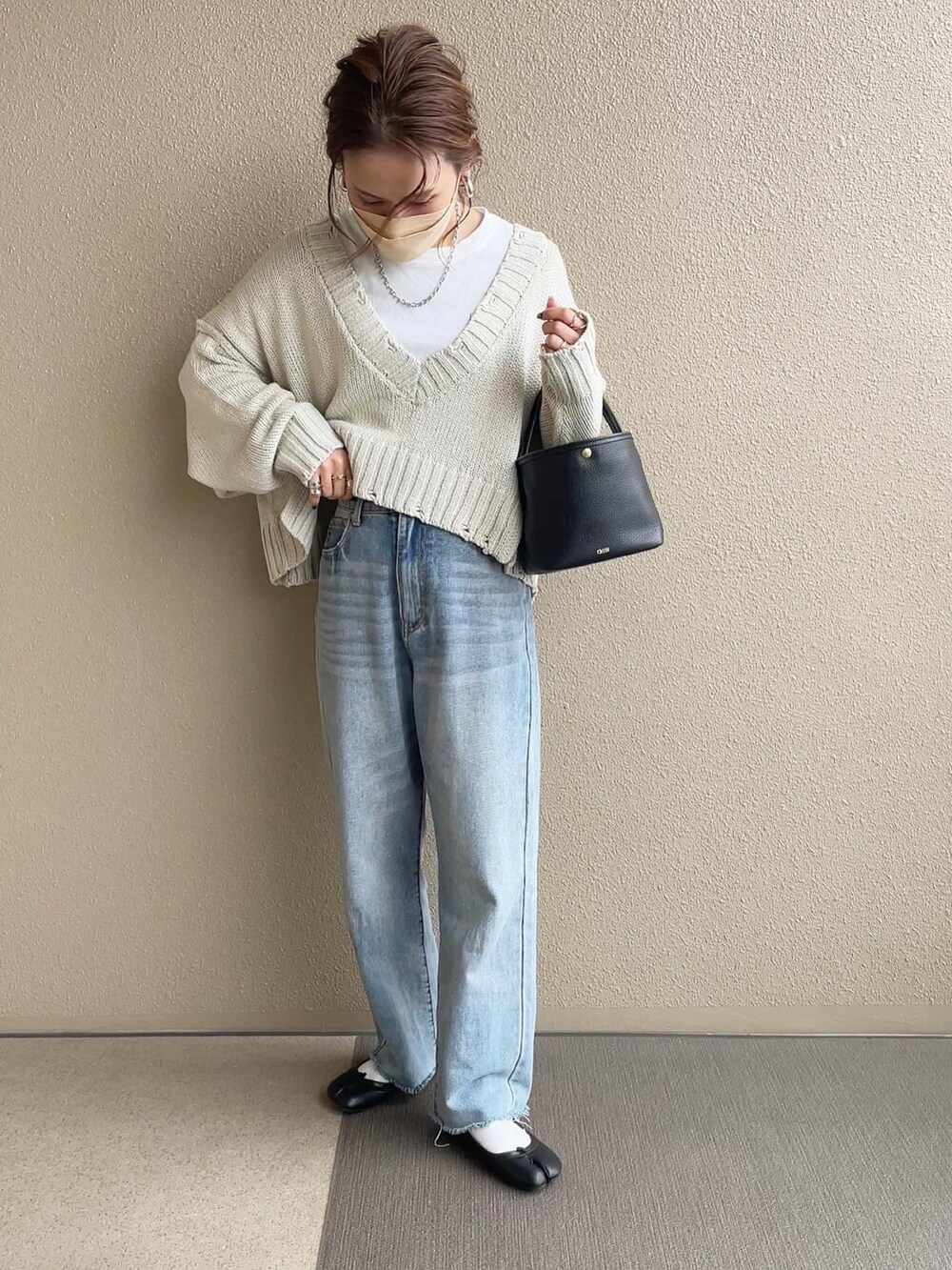 ホワイト系のニット/セーター、ブルー系のデニムパンツ、ブラウン系のシャツワンピースを着用したレディースの冬コーディネートの4枚目の写真