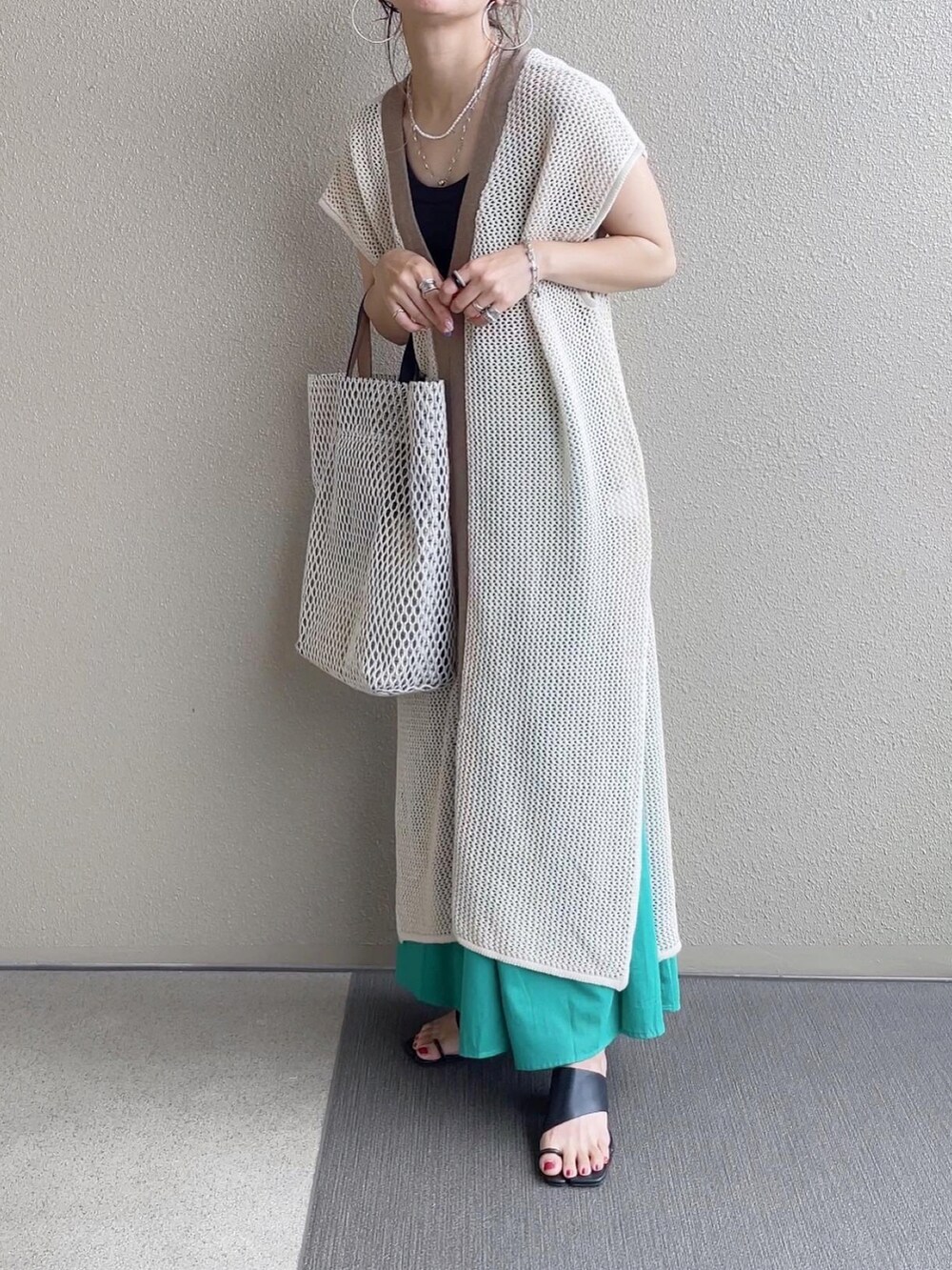グリーン系のスカート、ホワイト系のトップス、ホワイト系のバッグを着用したレディースの春コーディネートの3枚目の写真