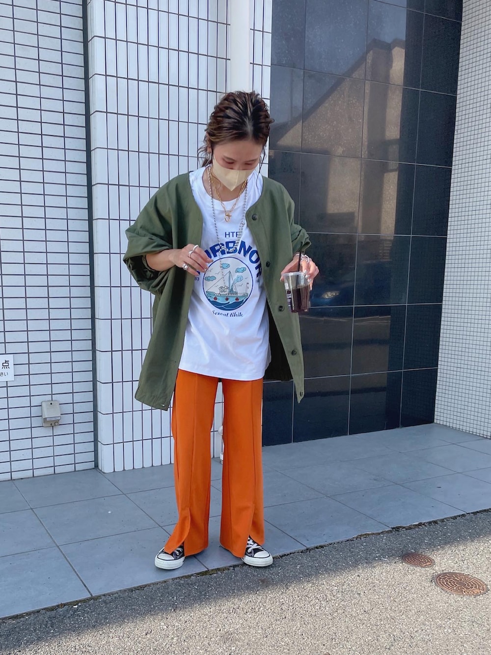 オレンジ系のスラックス、グリーン系のノーカラージャケットを着用したレディースの秋コーディネートの4枚目の写真