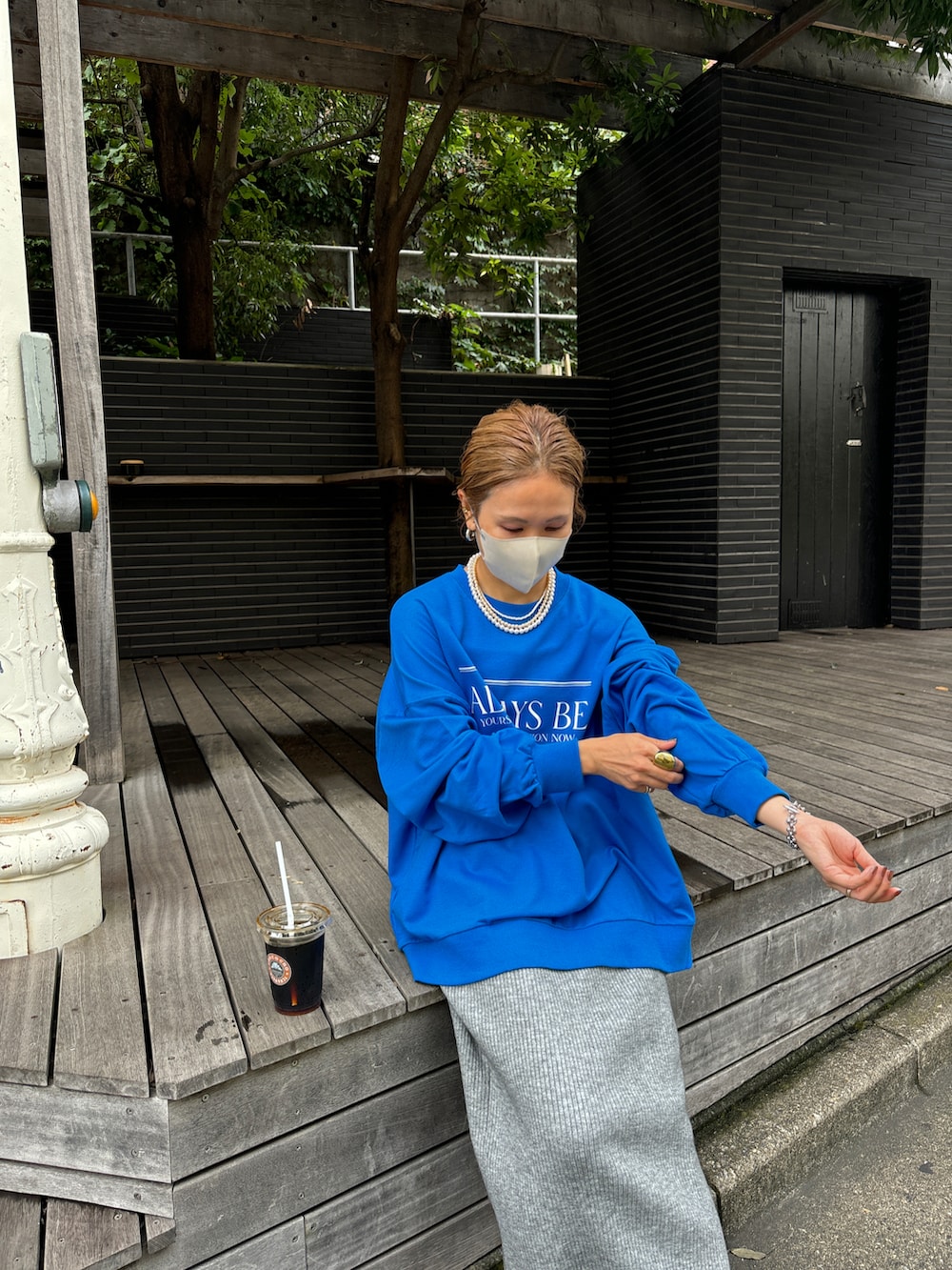 ブルー系のスウェット、グレー系のスカート、グレー系のスニーカーを着用したレディースの秋コーディネートの2枚目の写真