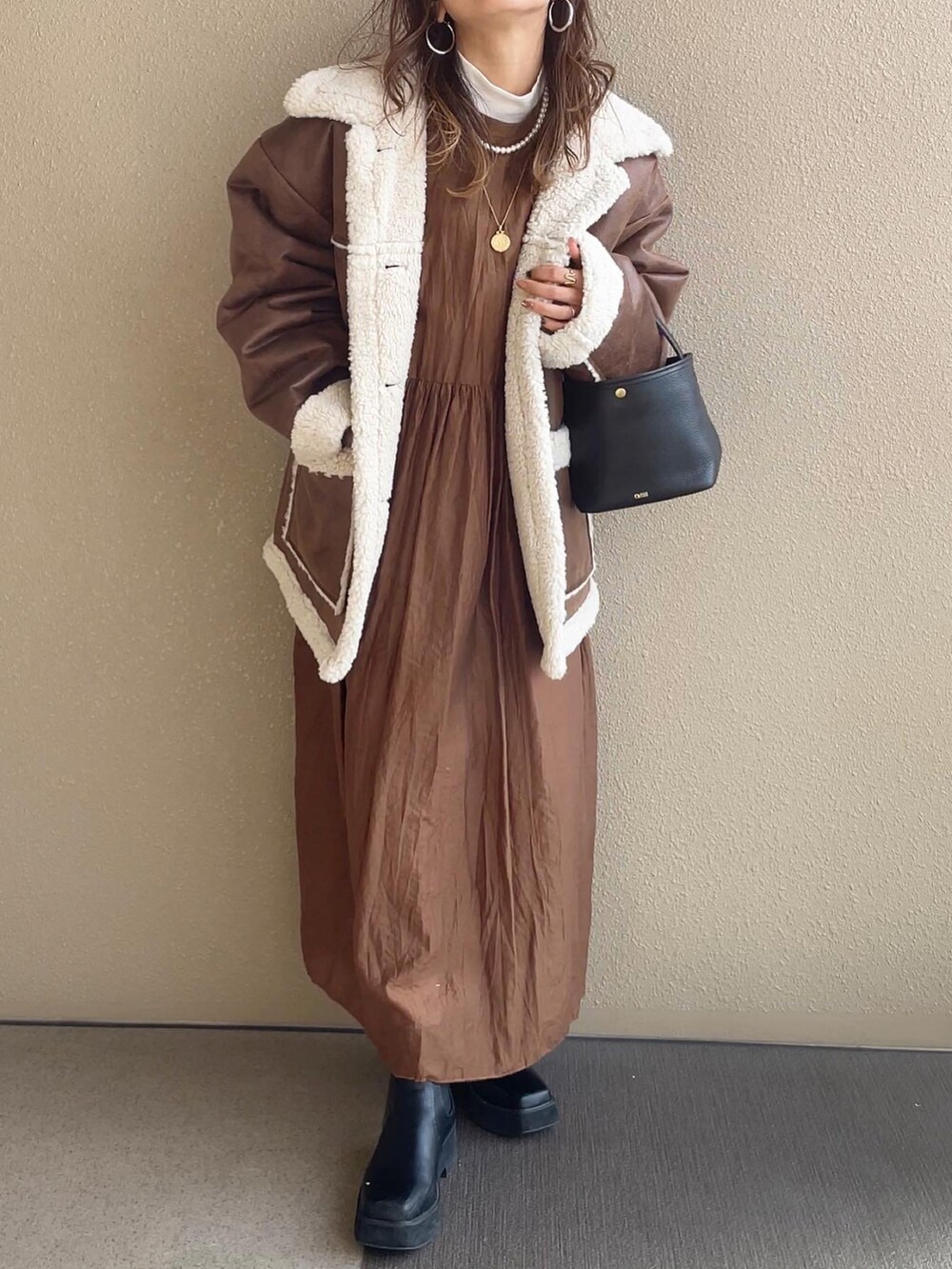 ブラウン系のムートンコート、ブラウン系のワンピース、その他のその他を着用したレディースの秋コーディネートの2枚目の写真