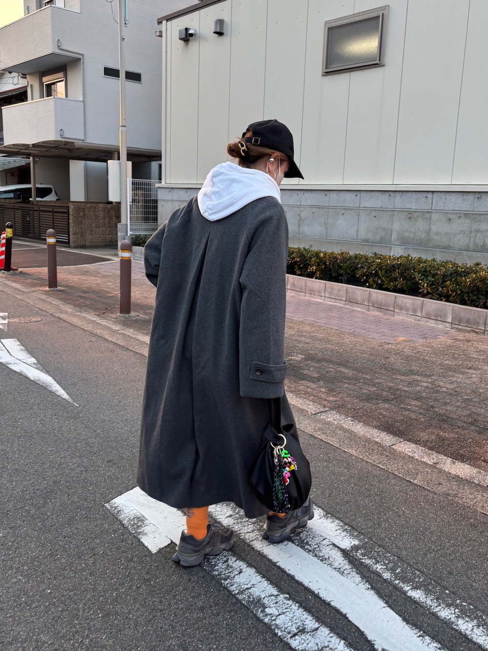 グレー系のステンカラーコートを着用したレディースの冬コーディネートの3枚目の写真