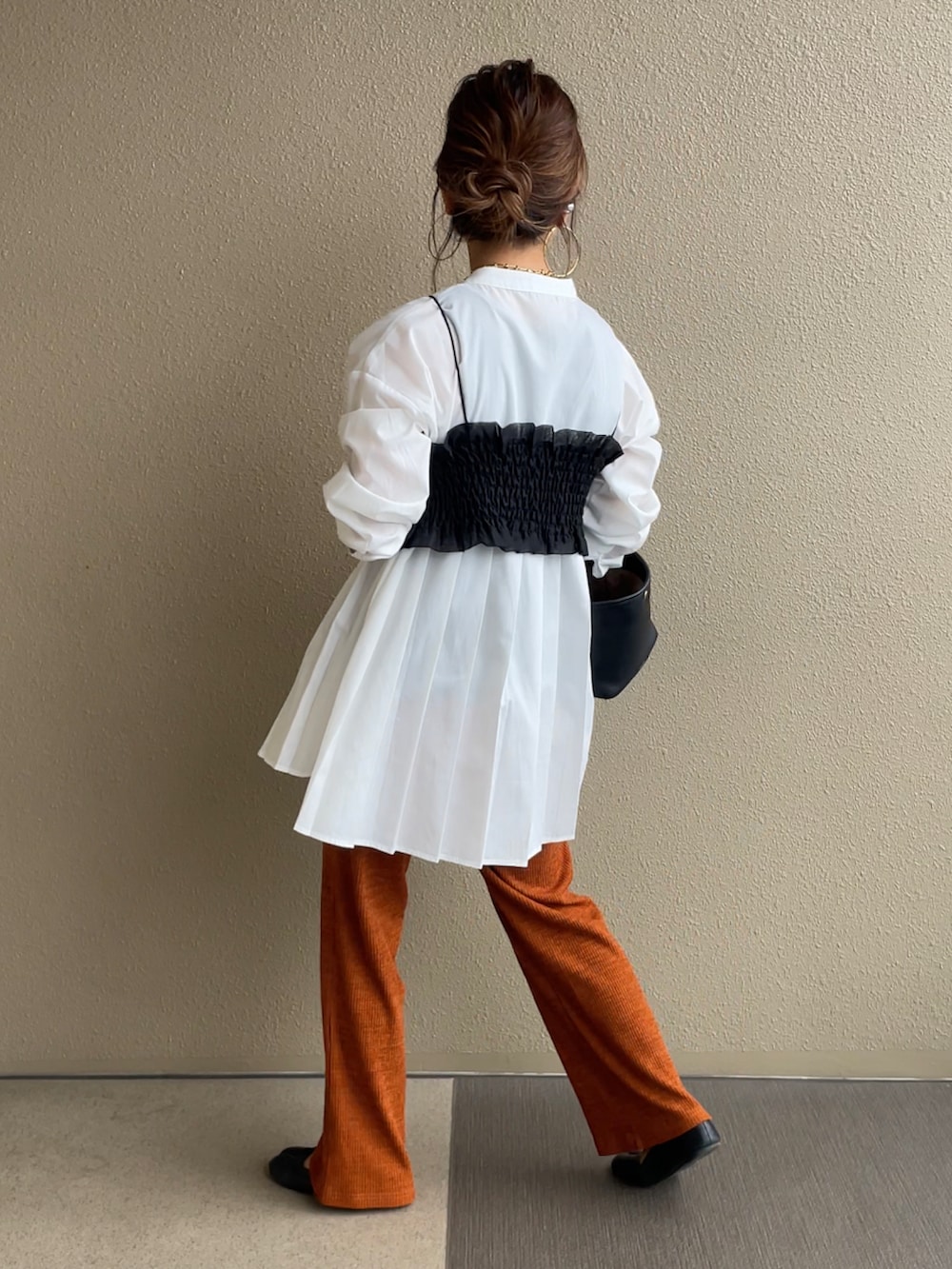 オレンジ系のその他パンツ、ホワイト系のシャツ/ブラウス、ブラック系のTシャツ/カットソーを着用したレディースの秋コーディネートの3枚目の写真