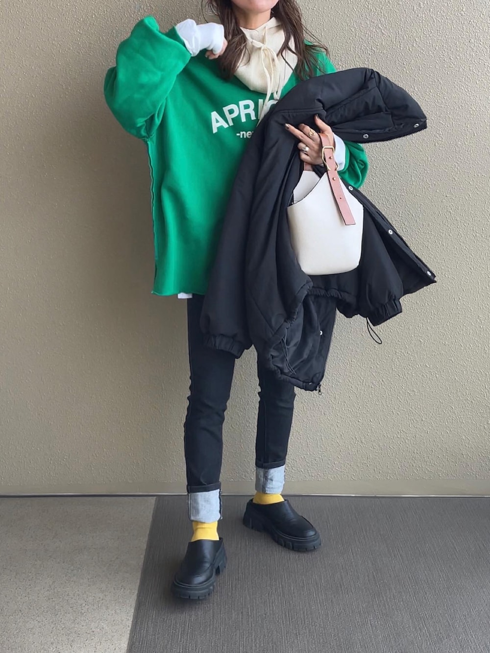 ブラック系のダウンジャケット/コート、グリーン系のスウェット、ホワイト系のニット/セーターを着用したレディースの冬コーディネートの2枚目の写真