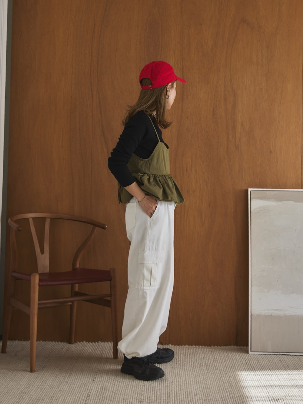 グリーン系のキャミソール、ブラック系のTシャツ/カットソー、ホワイト系のデニムパンツを着用したレディースの春コーディネートの2枚目の写真