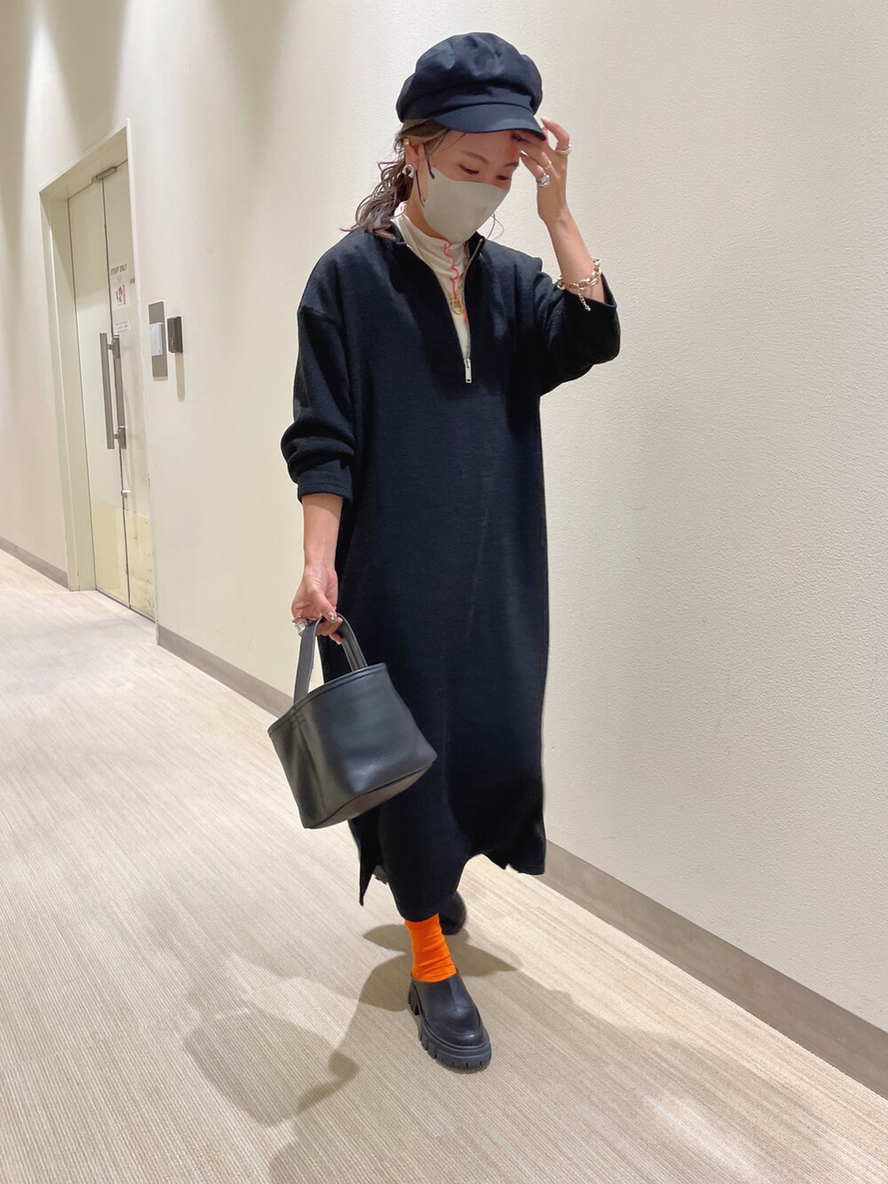 ブラック系のワンピース、ブラック系のスリッポン、ホワイト系のTシャツ/カットソーを着用したレディースの秋コーディネートの3枚目の写真