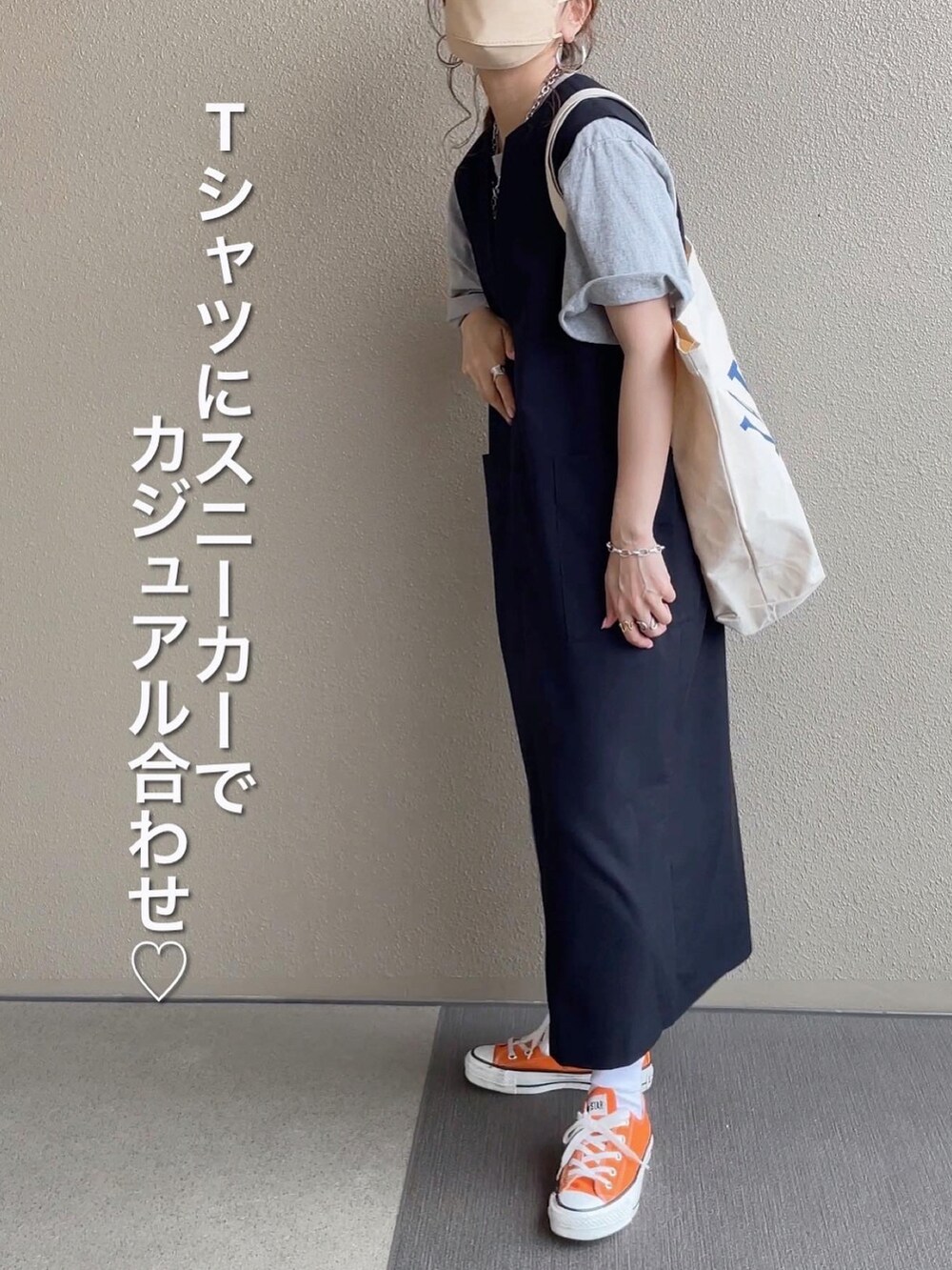 ブラック系のジャンパースカート、ピンク系のシャツ/ブラウス、グレー系のTシャツ/カットソーを着用したレディースの春コーディネートの3枚目の写真