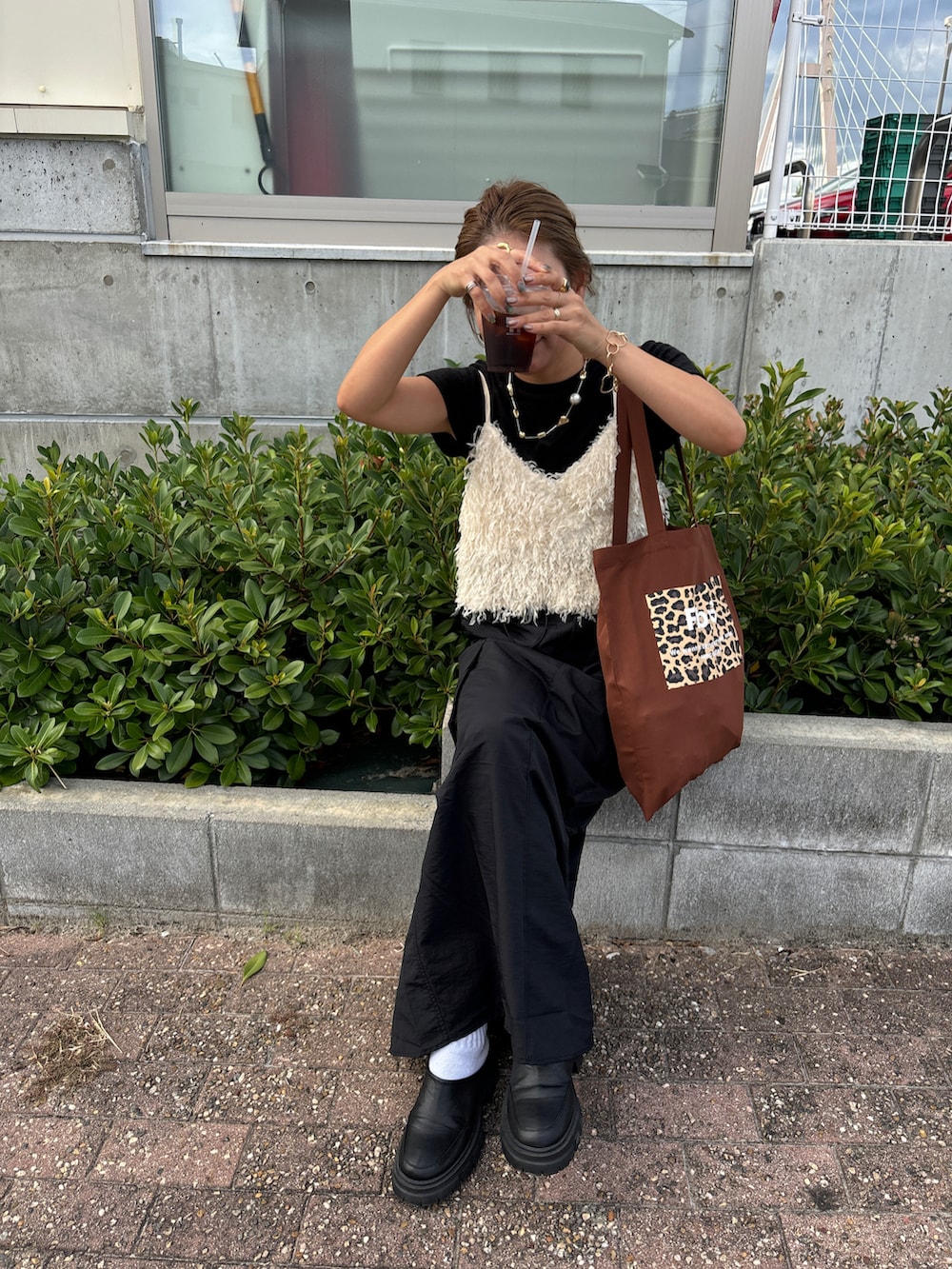 ブラック系のスカート、ホワイト系のシャツ/ブラウス、ブラック系のTシャツ/カットソーを着用したレディースの夏コーディネートの3枚目の写真