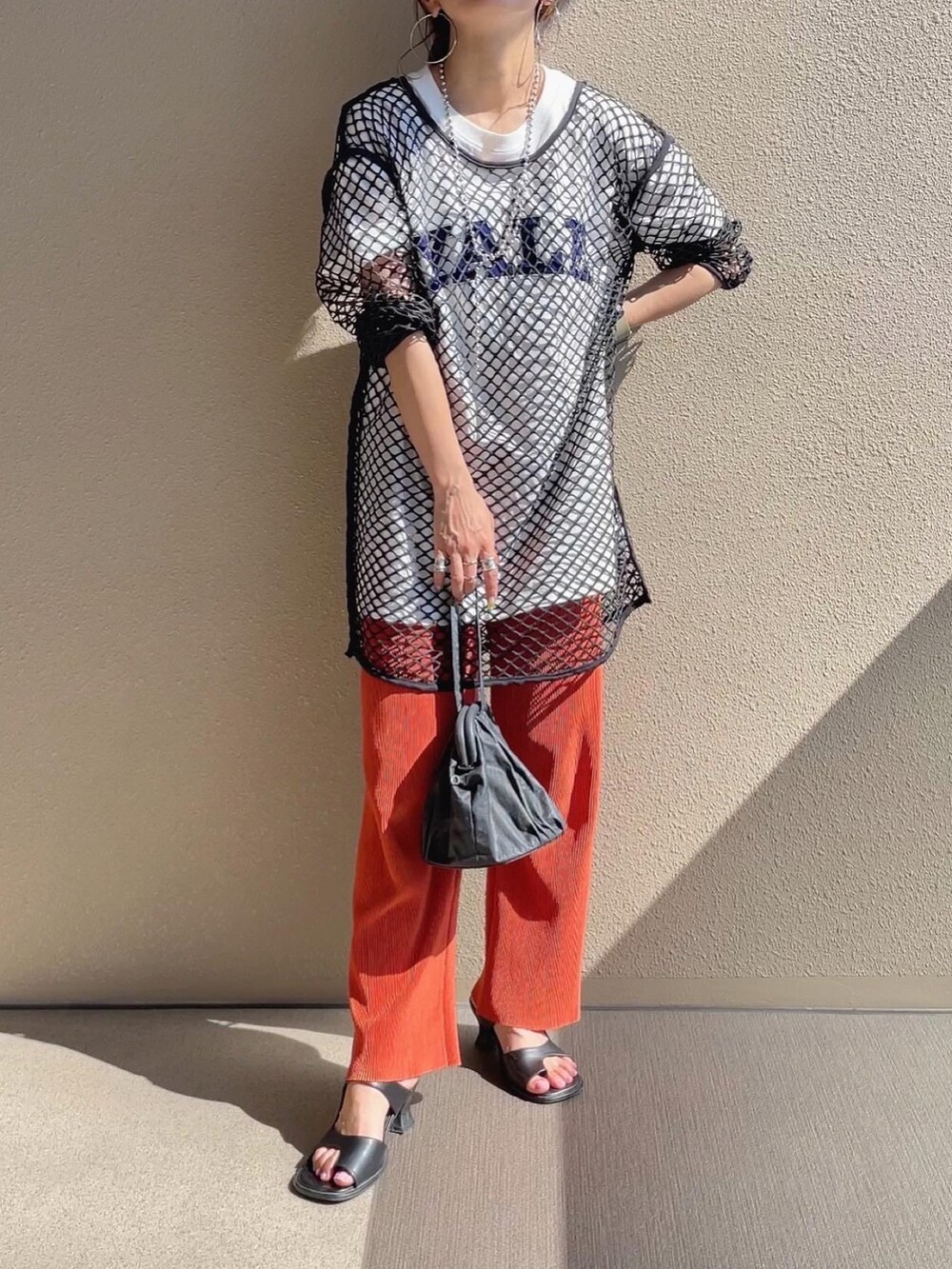 ホワイト系のTシャツ/カットソー、ブラック系のサンダル、グリーン系のベストを着用したレディースの夏コーディネートの3枚目の写真