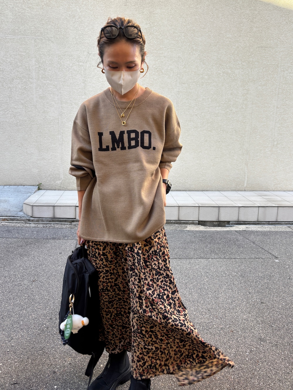 ブラック系のブーツ、ブラウン系のスカート、ブラウン系のニット/セーターを着用したレディースの秋コーディネートの2枚目の写真