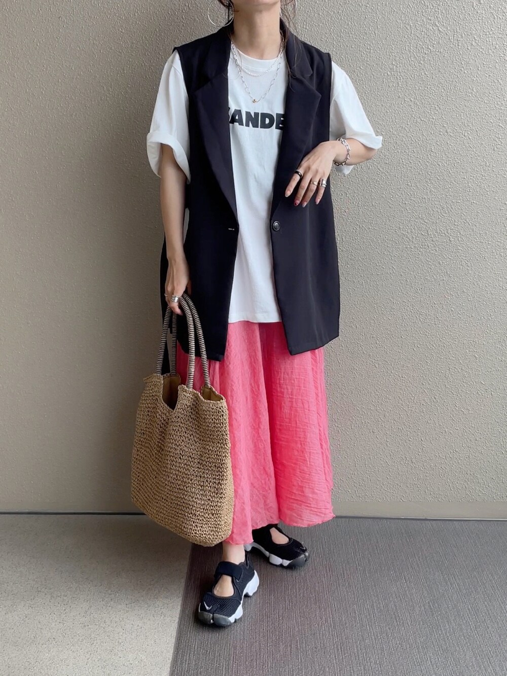 オレンジ系のスカート、ブルー系のシャツ/ブラウス、ブラック系のニット/セーターを着用したレディースの春コーディネートの4枚目の写真