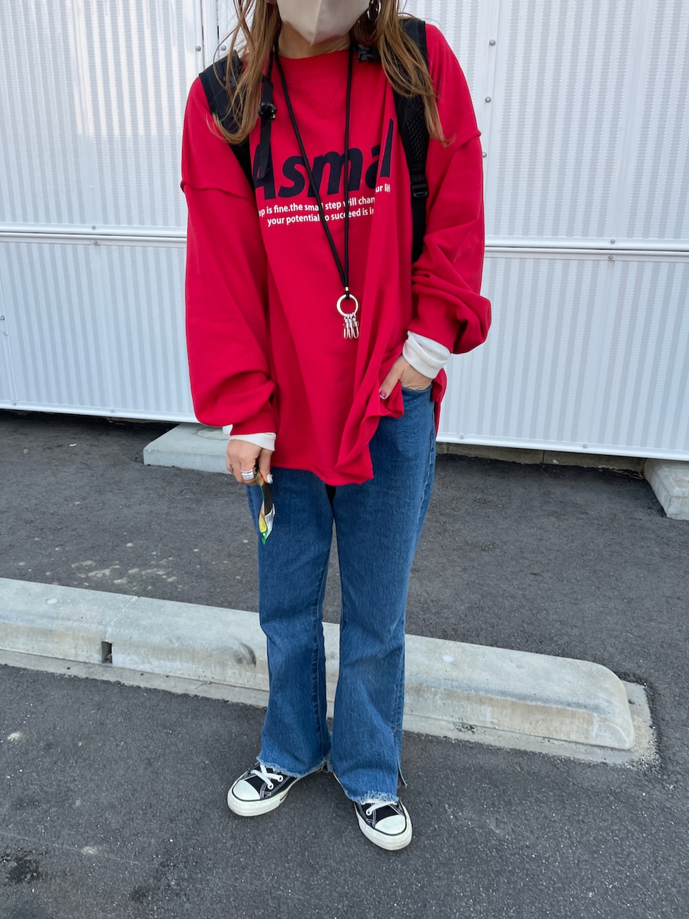 レッド系のスウェット、ブルー系のデニムパンツを着用したレディースの冬コーディネートの4枚目の写真