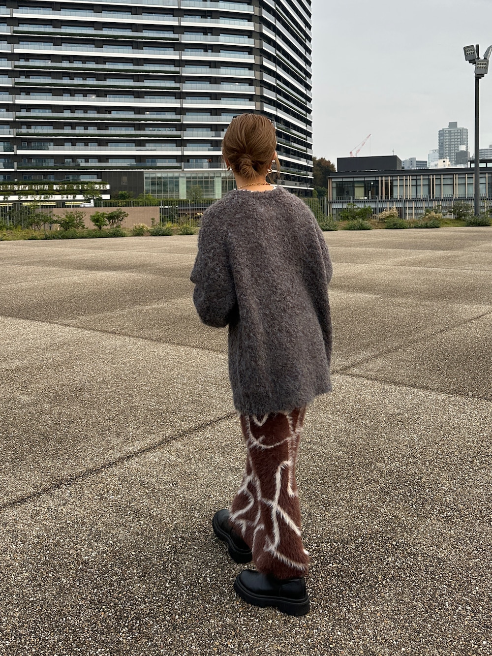 グレー系のニット/セーター、ブラウン系のスカートを着用したレディースの冬コーディネートの4枚目の写真