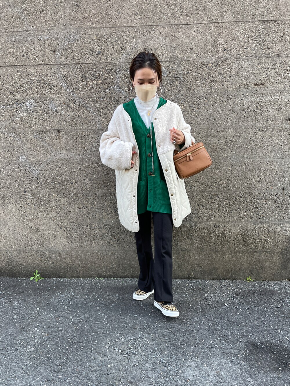ホワイト系のノーカラージャケット、グリーン系のカーディガン/ボレロ、ブラック系のその他パンツを着用したレディースの冬コーディネートの2枚目の写真