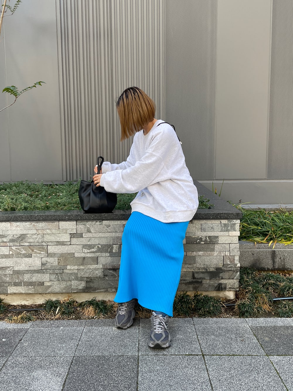 グレー系のTシャツ/カットソー、ブラック系のハンドバッグを着用したレディースの冬コーディネートの2枚目の写真