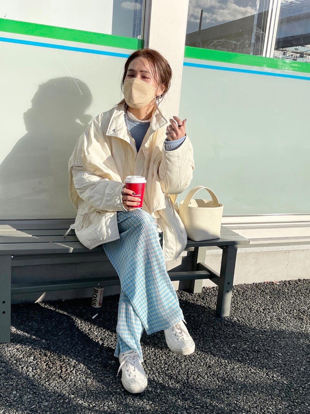 ホワイト系のダウンジャケット/コート、ブルー系のニット/セーター、ホワイト系のスニーカーを着用したレディースの冬コーディネートの3枚目の写真