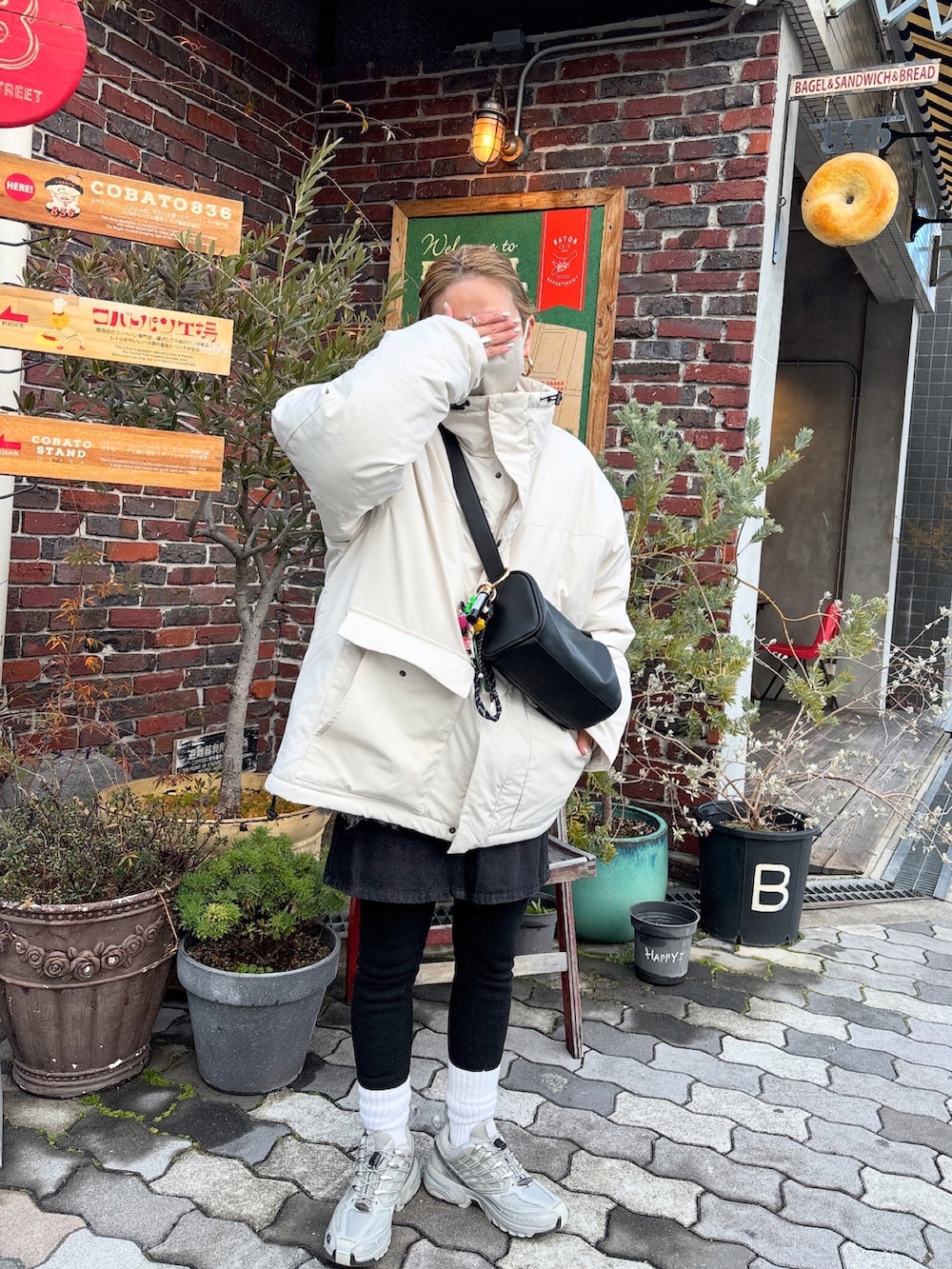 ブラック系のショルダーバッグ、ピンク系のニット/セーターを着用したレディースの冬コーディネートの3枚目の写真