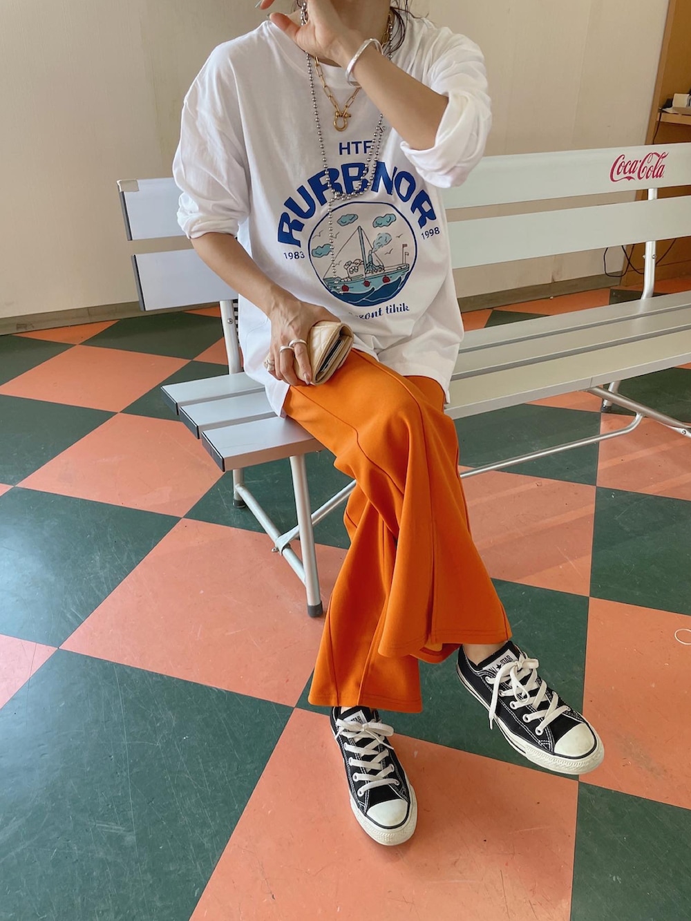 オレンジ系のスラックス、グリーン系のノーカラージャケットを着用したレディースの秋コーディネートの2枚目の写真