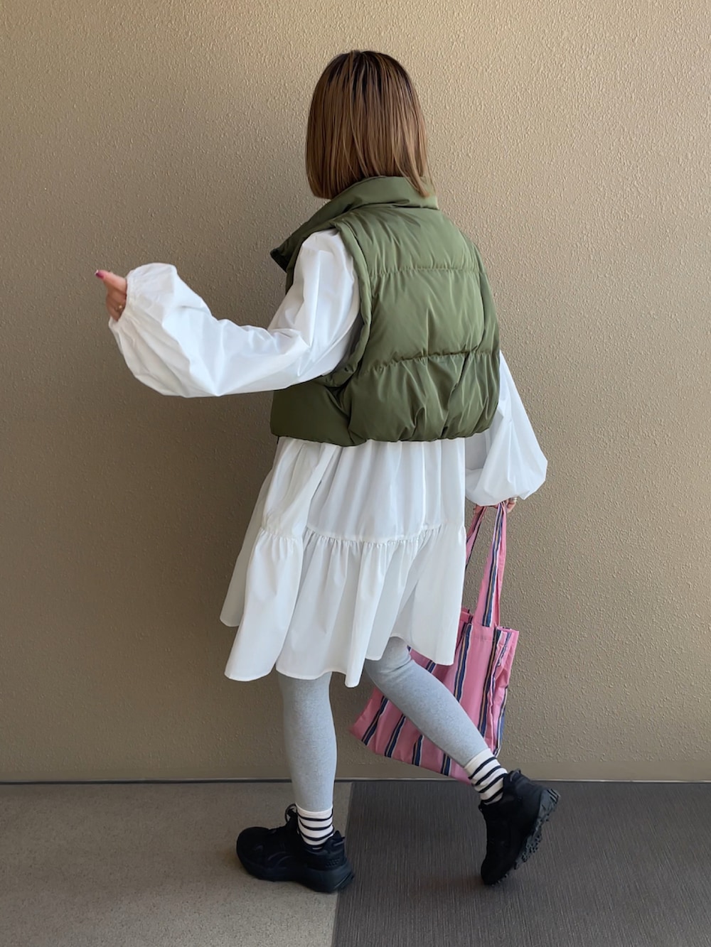 ホワイト系のシャツ/ブラウス、グリーン系のベスト、グレー系のレギンス/スパッツを着用したレディースの冬コーディネートの3枚目の写真