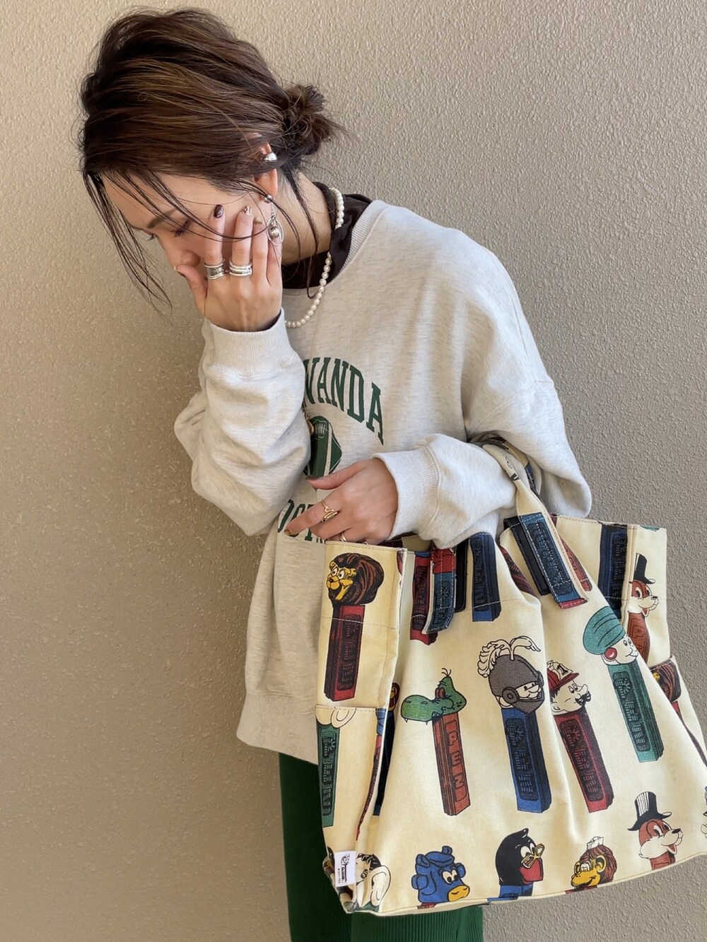 グレー系のスウェット、グリーン系のパンツ、ホワイト系のトートバッグを着用したレディースの冬コーディネートの3枚目の写真