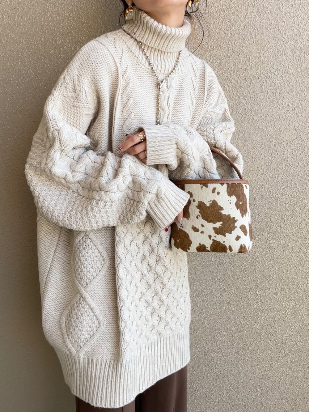 ホワイト系のノーカラージャケット、ホワイト系のニット/セーター、ブラウン系のその他パンツを着用したレディースの冬コーディネートの2枚目の写真