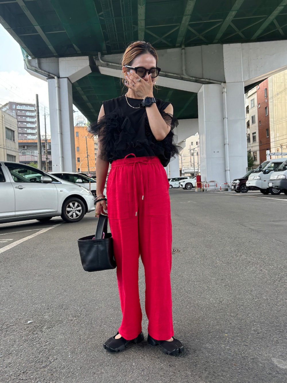 レッド系のその他パンツ、ブラック系のその他トップス、ブラック系のサンダルを着用したレディースの夏コーディネートの2枚目の写真