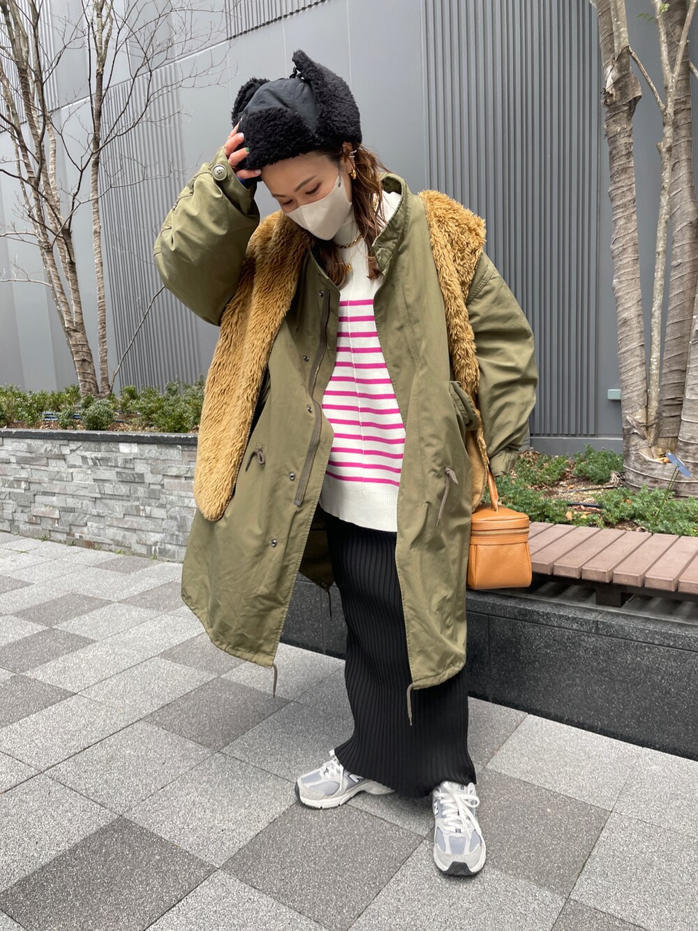 ピンク系のカーディガン/ボレロ、ブラック系のスカート、グリーン系のモッズコートを着用したレディースの冬コーディネートの3枚目の写真