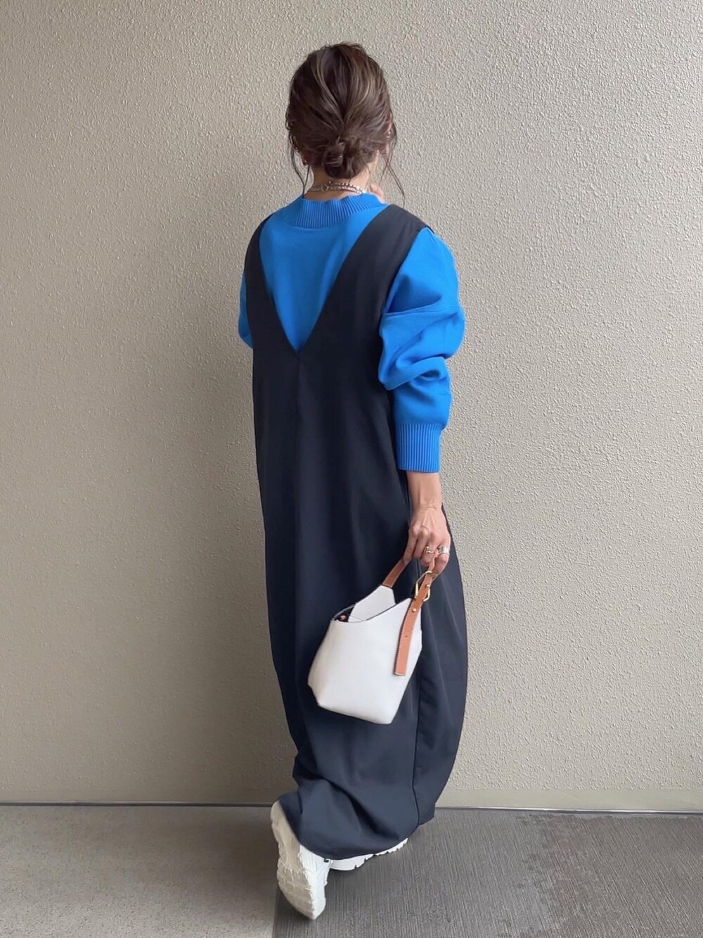 ブルー系のニット/セーター、ベージュ系のスカート、ホワイト系のベストを着用したレディースの秋コーディネートの5枚目の写真