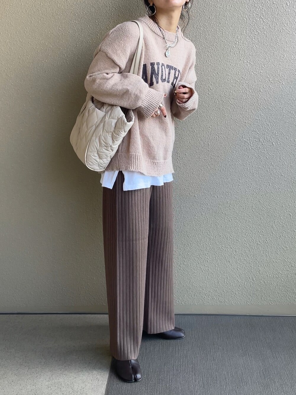 ベージュ系のニット/セーター、ブラウン系のその他パンツ、ベージュ系のトートバッグを着用したレディースの冬コーディネートの3枚目の写真