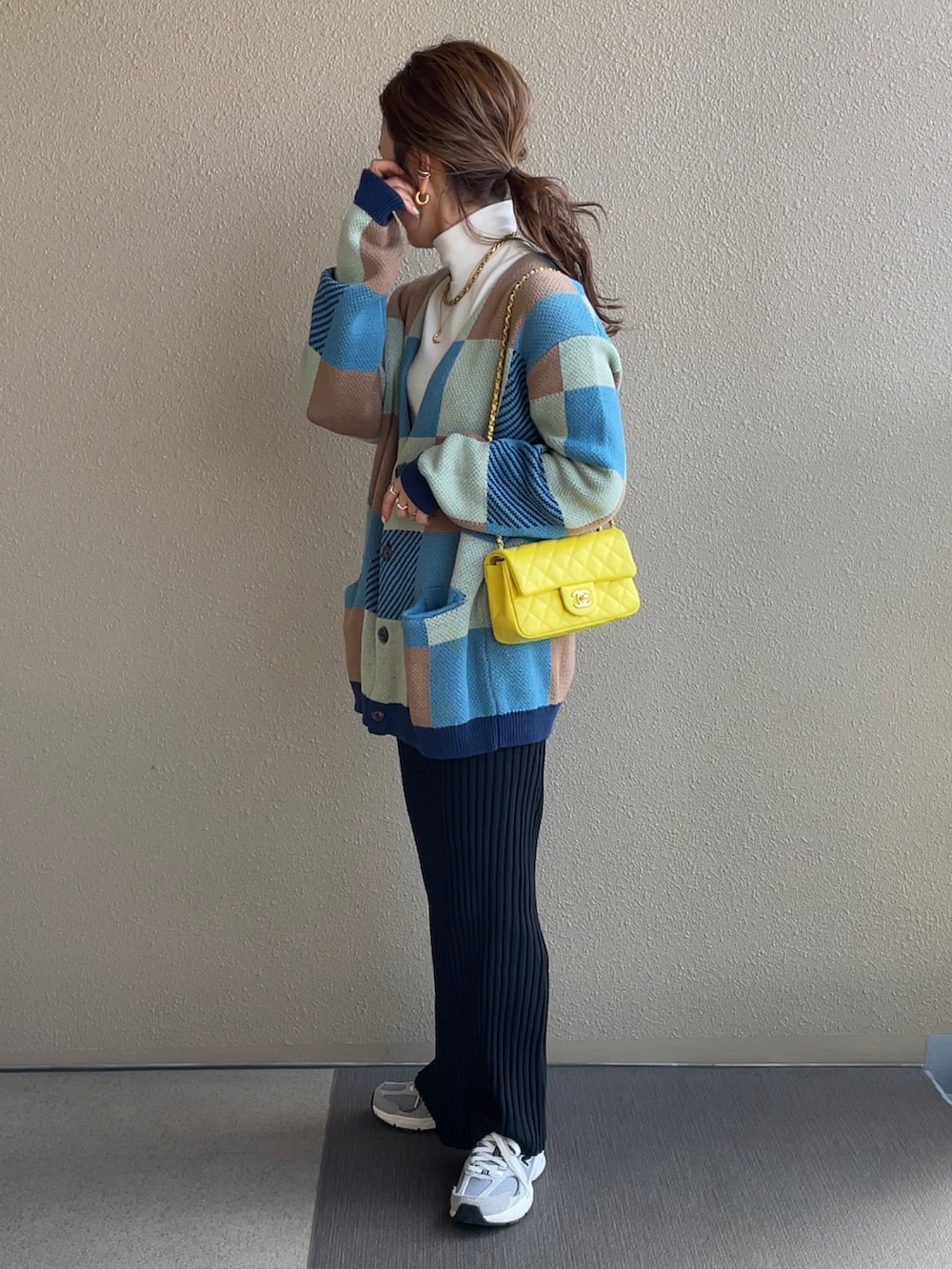 グリーン系のカーディガン/ボレロ、ブラック系のスカート、ベージュ系のステンカラーコートを着用したレディースの冬コーディネートの3枚目の写真