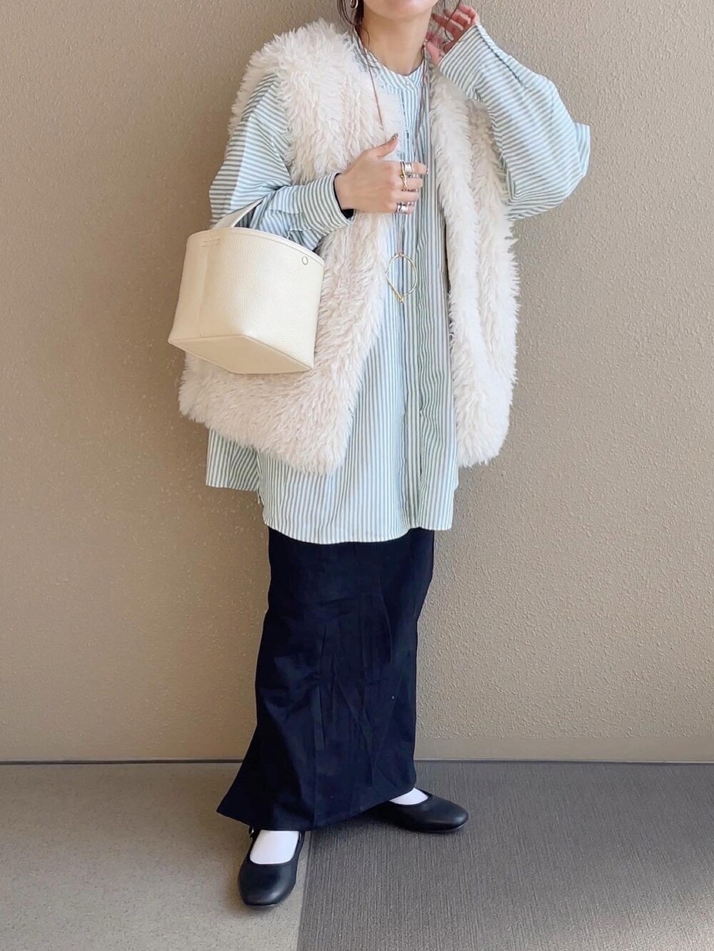 ブラック系のスカート、グリーン系のシャツ/ブラウス、ホワイト系のベストを着用したレディースの冬コーディネートの3枚目の写真