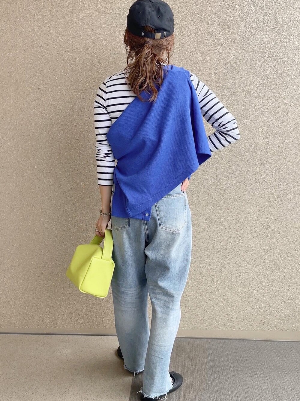 ブルー系のカーディガン/ボレロ、ブルー系のデニムパンツ、ブラック系のワンピースを着用したレディースの春コーディネートの2枚目の写真