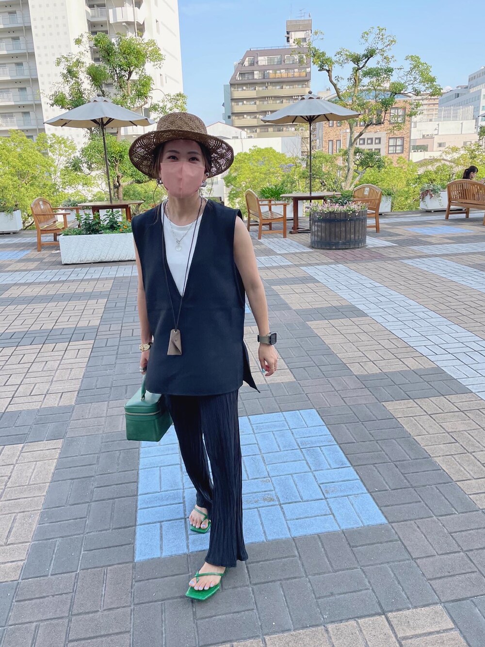 ブラック系のベスト、ブラック系のその他パンツ、グリーン系のサンダルを着用したレディースの夏コーディネートの2枚目の写真